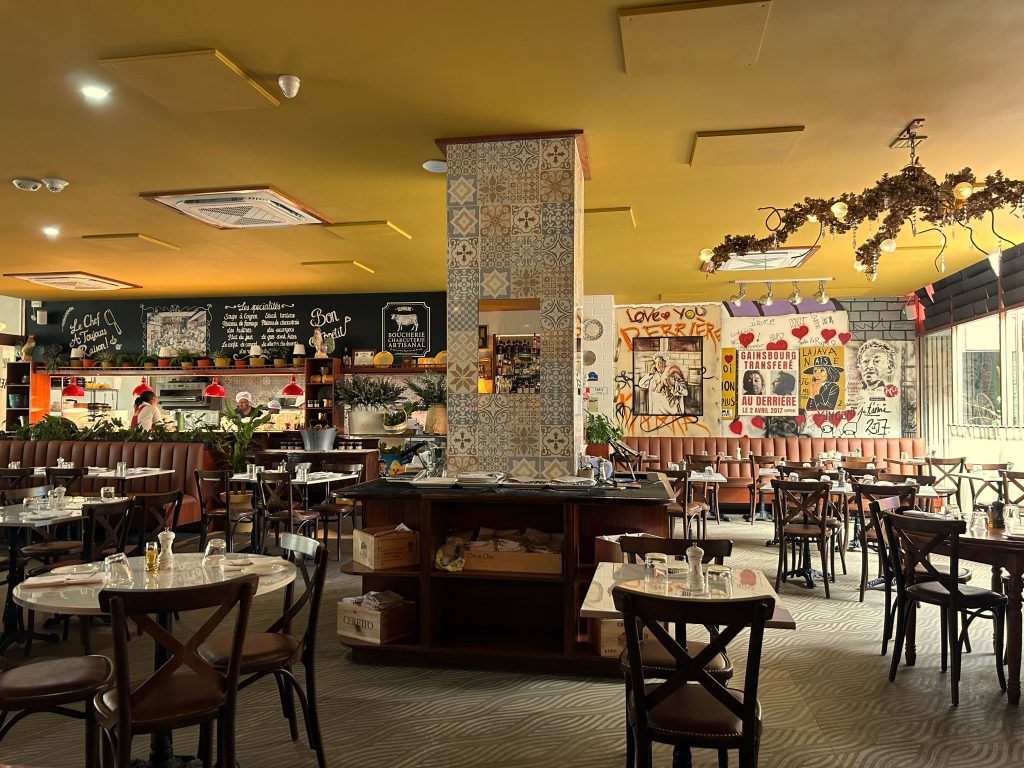 French-style restaurant with chairs and tables and a bar in the background