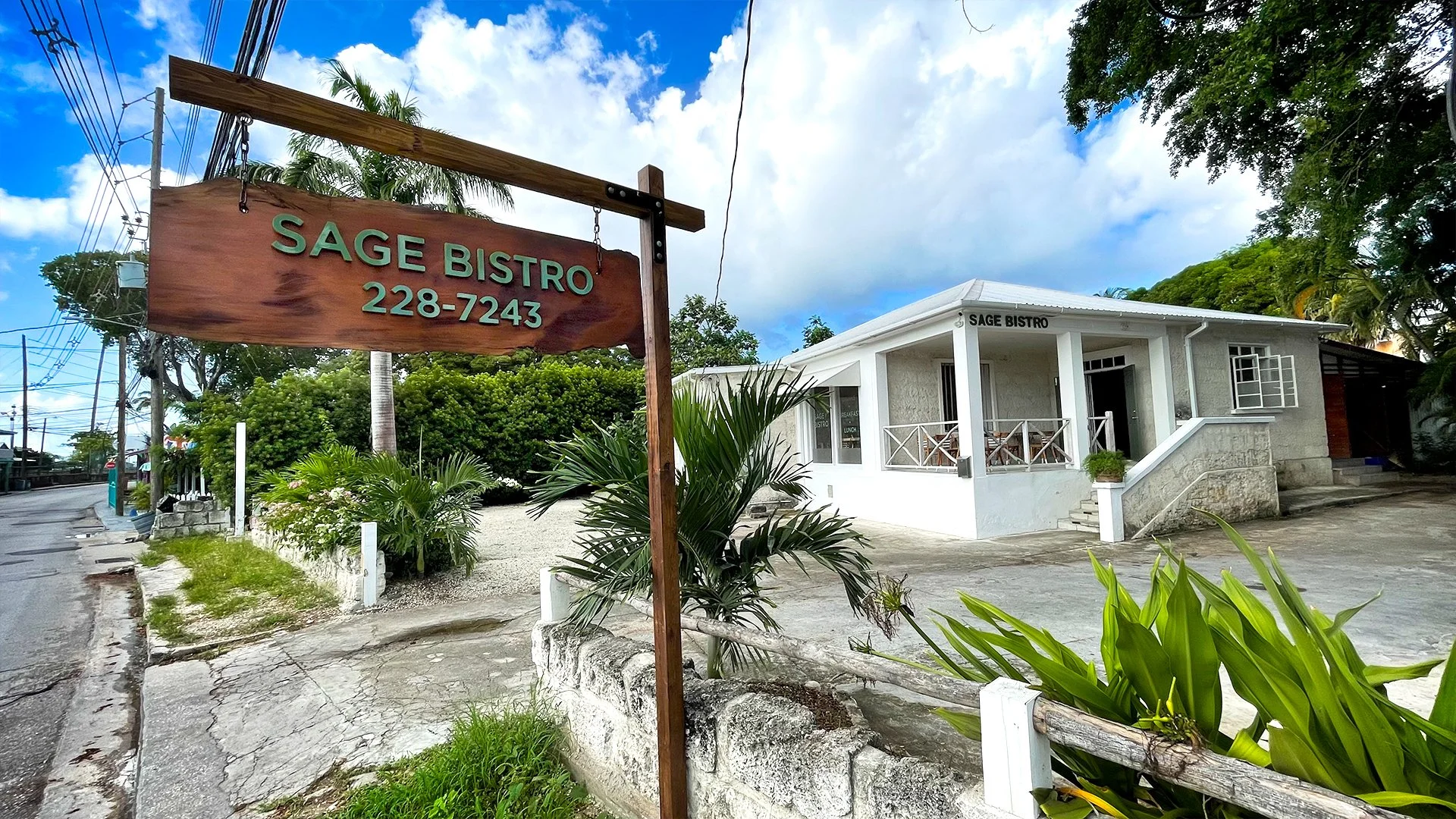 restaurant with sage bistro sign outside surrounded by ferns and greenery