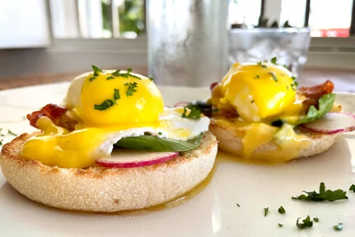 eggs benedict on circular muffin with eggs
