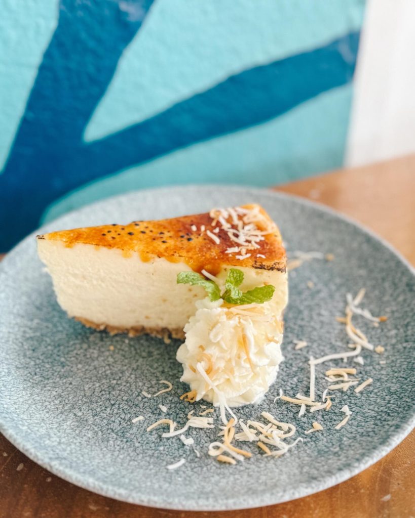 slice of cheese cake with cream next to it on a plate