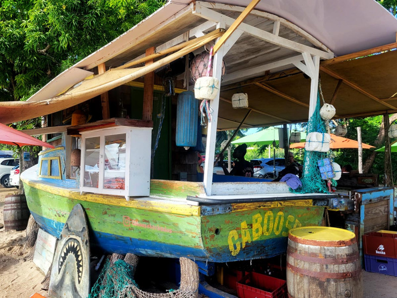 green boat turned into restaurant on a beach